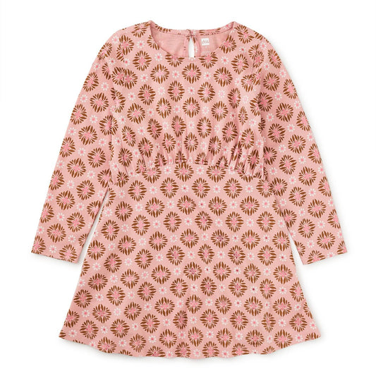 A long sleeve, pink, floral dress with a wrap neckline and a curved waist.