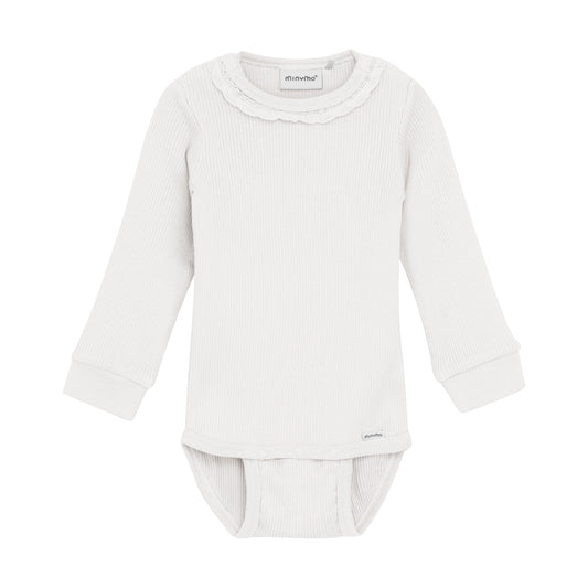 White baby outfit with long-sleeve top and pants on a white background