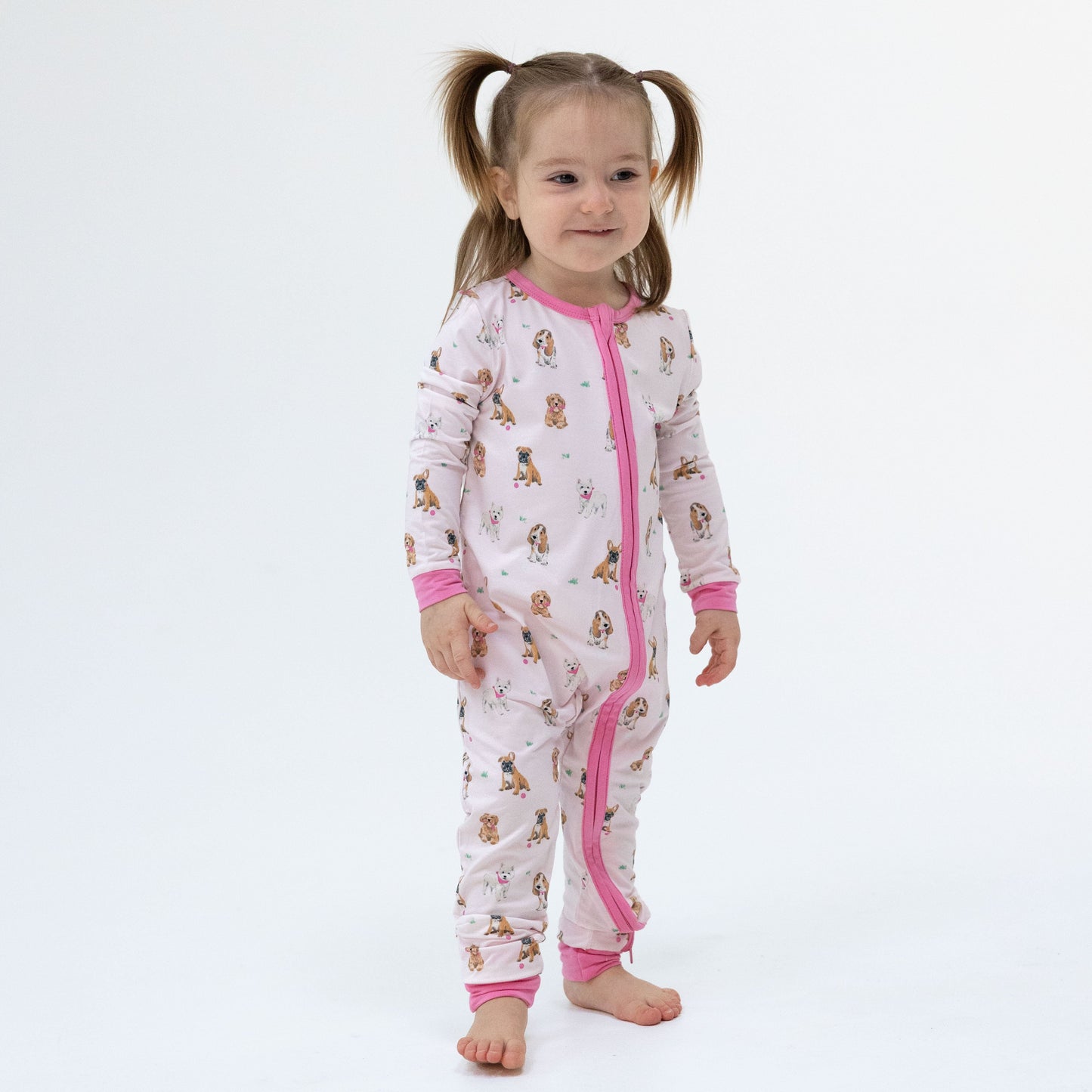Baby wearing Angel Dear Besties Dogs Flip Romper in pink, lifestyle photo