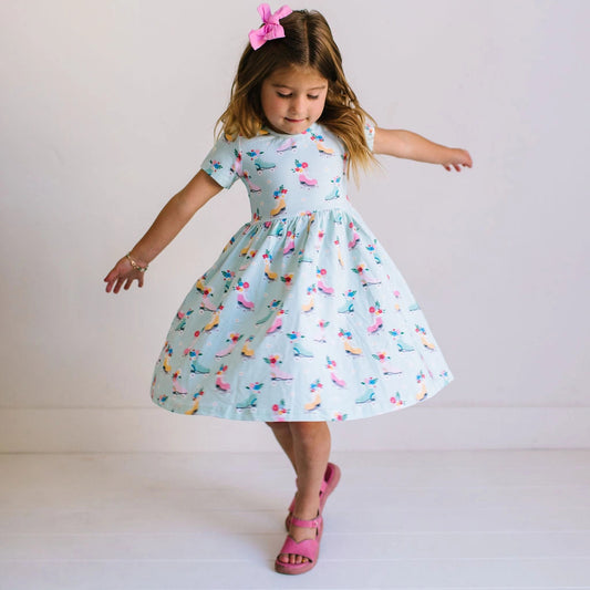 Young girl wearing a patterned dress on a plain background