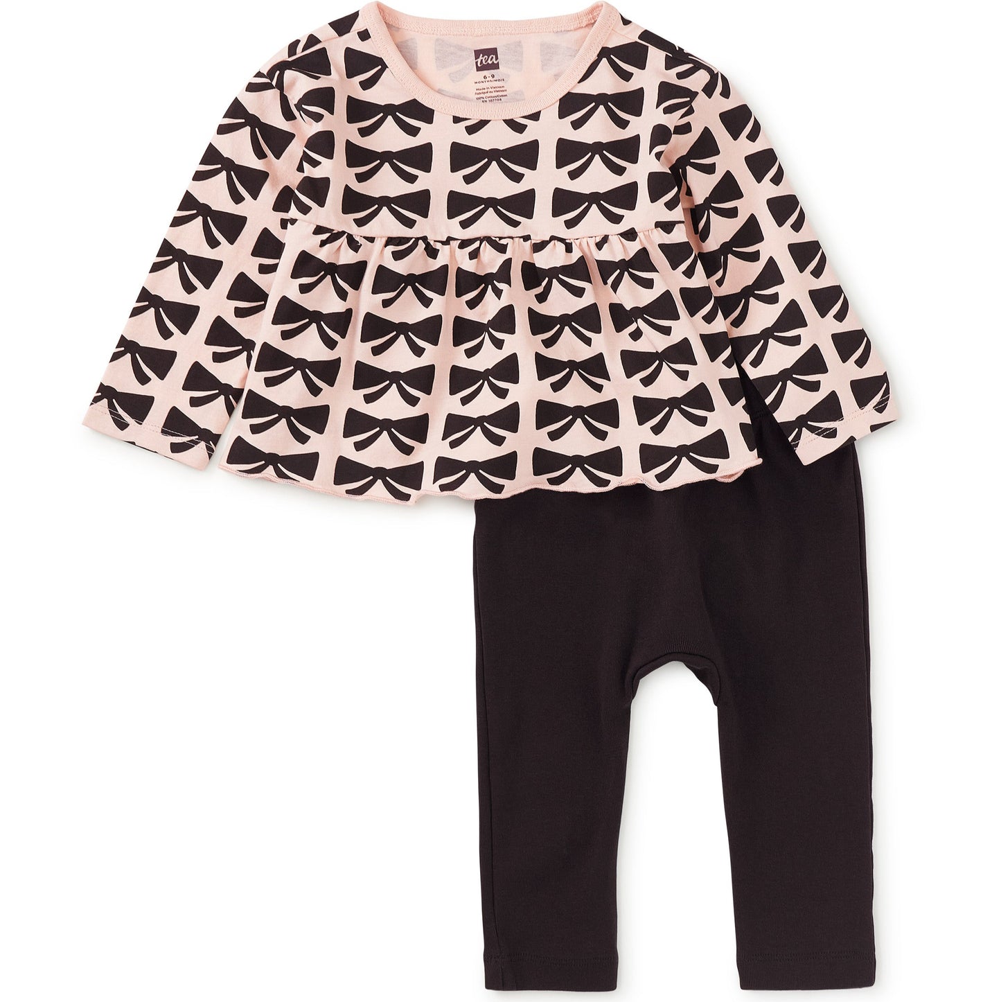 Children's outfit with patterned top and black pants on a white background