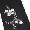 Black fabric with white floral embroidery on a white background