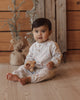 Dalmatian print baby romper in a soft fog color with a two-button henley front