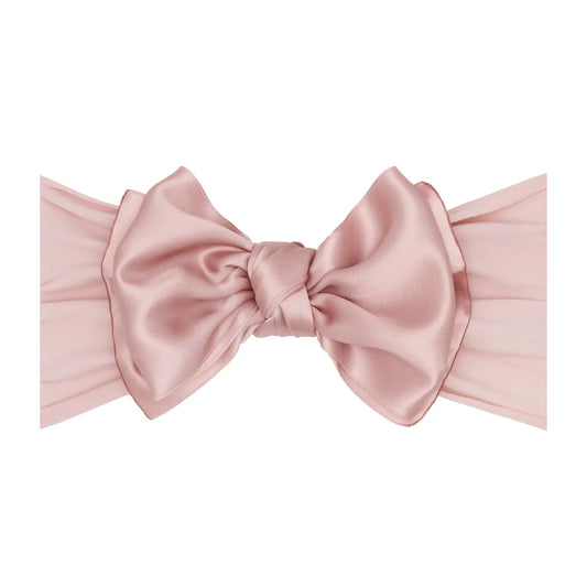 Pink satin headband with a large bow on a white background