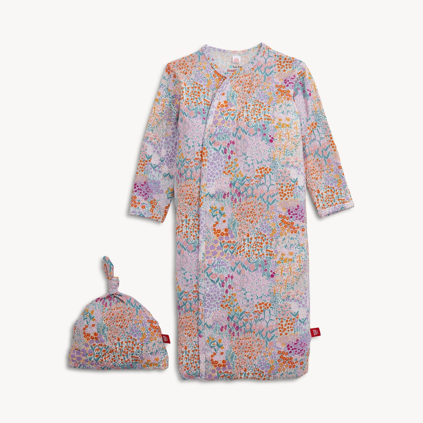 A baby hat and gown set with a colorful floral and abstract print on a light pink background.