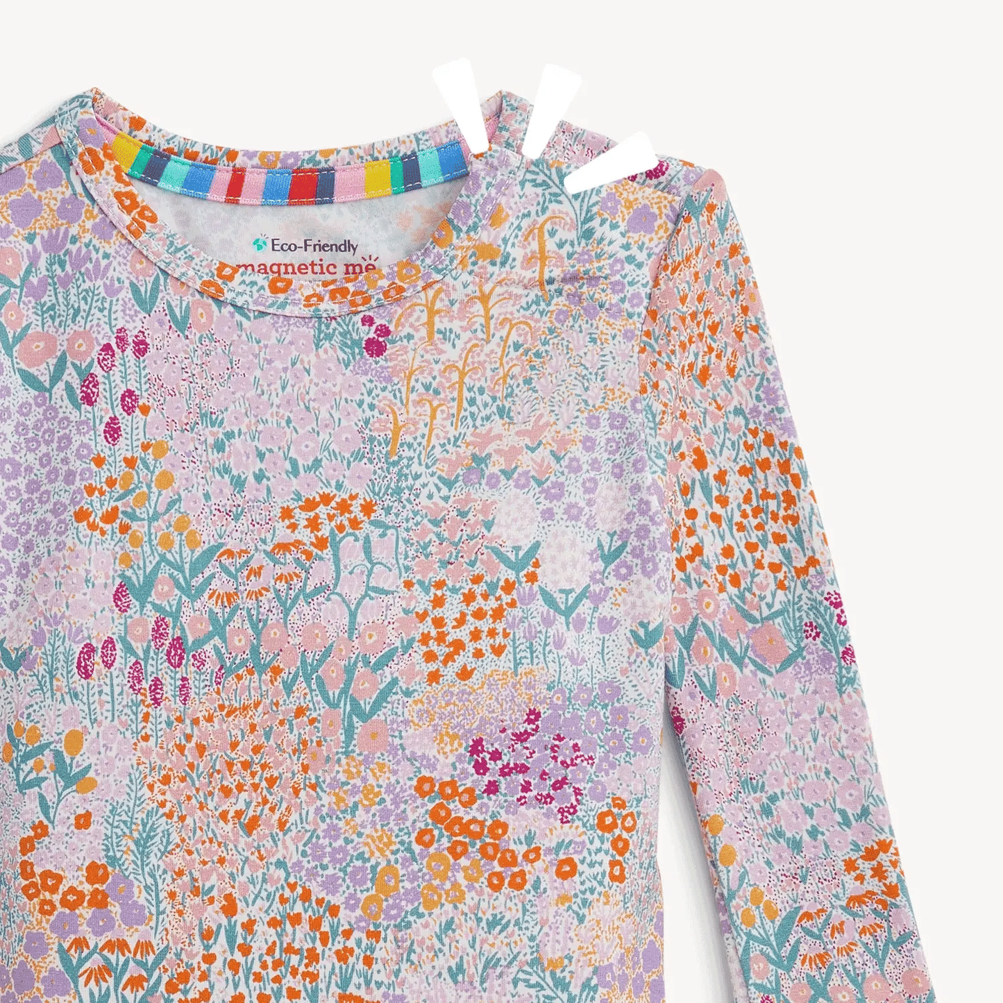 A close up of a baby pajama top featuring a pink base with a floral all over print, multicolored floral pattern.