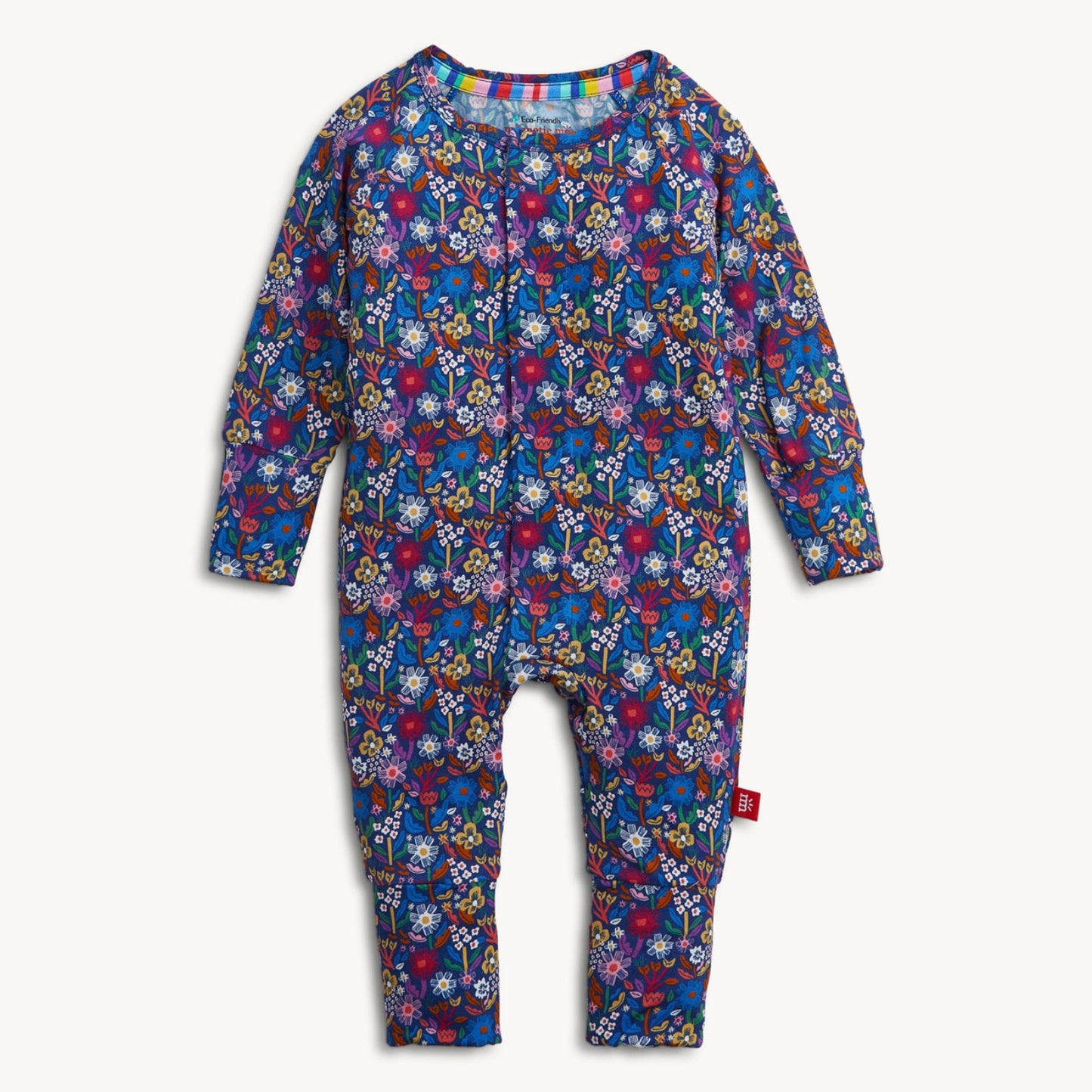 A baby long-sleeve footless one-piece jumpsuit with an all-over colorful floral and abstract pattern on a dark blue base, shown flat against a light off-white background.