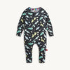 A baby long-sleeve with convertible footies one-piece pajama with an all-over dinosaur print on a black background, shown flat against a light off-white background.