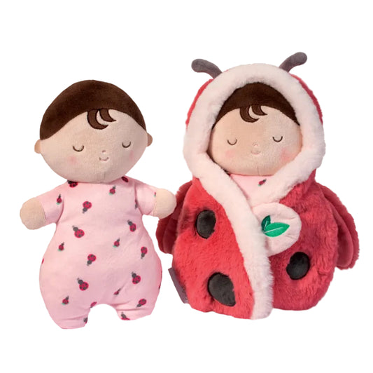 Two plush toys: one in a pink outfit with ladybug pattern and the other in a red ladybug costume.