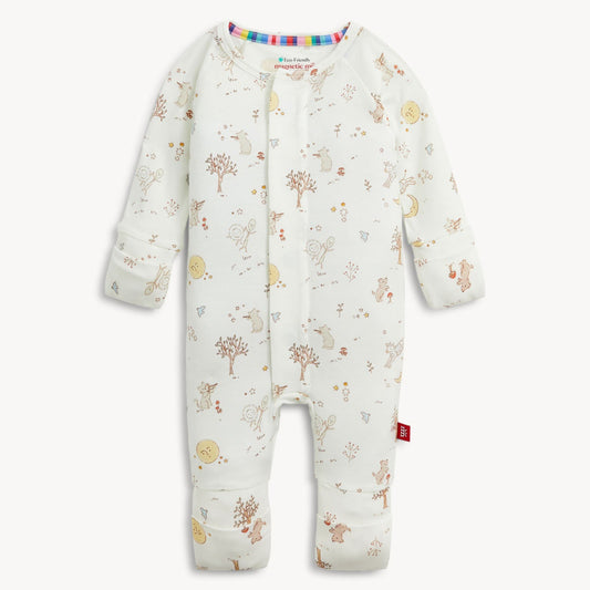 A baby long-sleeve footless one-piece romper in off-white, decorated with a whimsical woodland print of trees, birds, flowers, and stars. The romper features a colorful striped inner collar and a small red tag on the lower leg, shown against a plain light background.