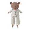 A plush teddy bear doll wearing a beige and white gingham pajama set, photographed against a solid light gray background.