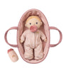 Baby doll in a pink crib with a pacifier on a white background