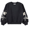 Black sweatshirt with floral embroidery on sleeves against a white background