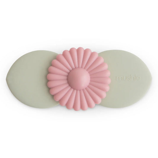 Pink flower-shaped object with green oval bases on a white background