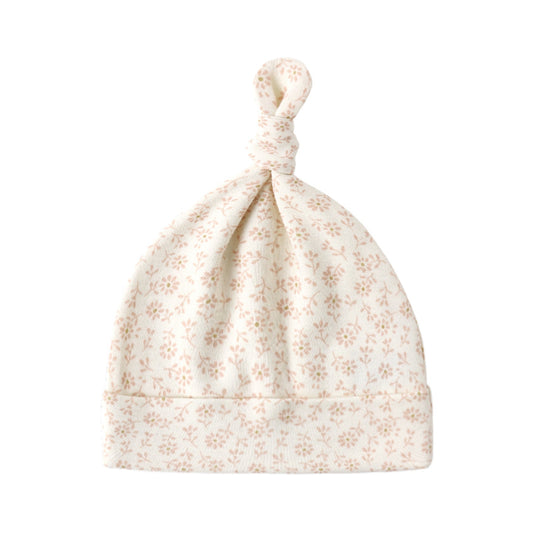 Ditsy floral patterned baby hat on a white background