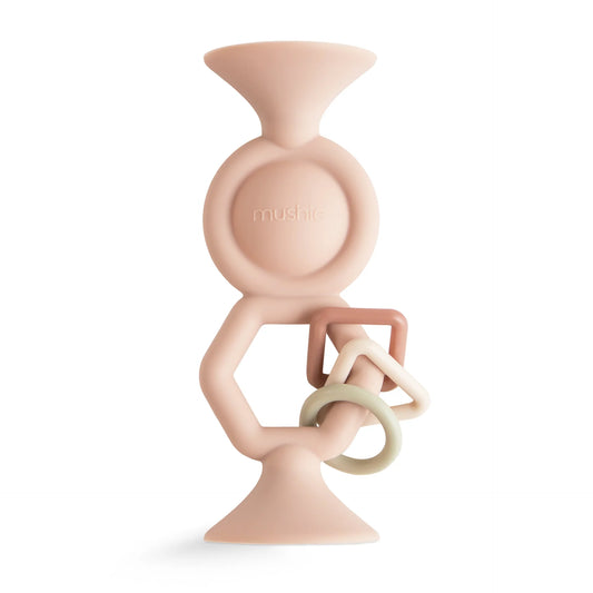 Pink baby teether with rings on a white background