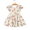 White dress with pink butterfly pattern on a hanger 