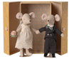Two toy mice, one in a wedding dress and the other in a suit, standing in front of an ornate box.