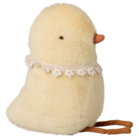 Stuffed toy chick with a lace collar and brown rope on a white background
