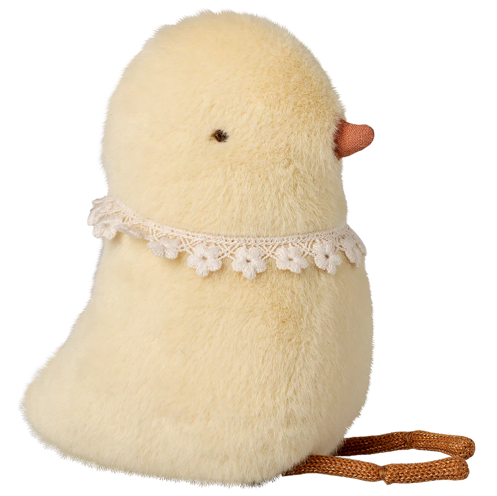 Stuffed toy chick with a lace collar and brown rope on a white background