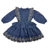 A vintage-style blue dress for girls featuring long puff sleeves, a ruffled high neck, and tiered skirt with gold floral embroidery and scalloped edges.