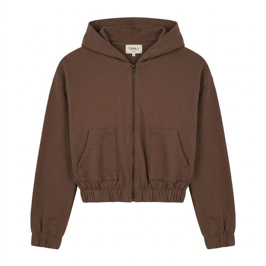A brown zip-up hoodie sweatshirt with a high collar and elastic cuffs, hanging on a white hanger against a plain white wall.