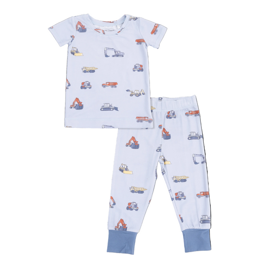 Children's pajama set with construction vehicle pattern on a light blue background