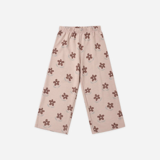 A pair of light pink track pants with an elastic waistband and an all-over flower pattern.
