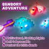 Six colorful light-up dinosaur bath toys on white background.