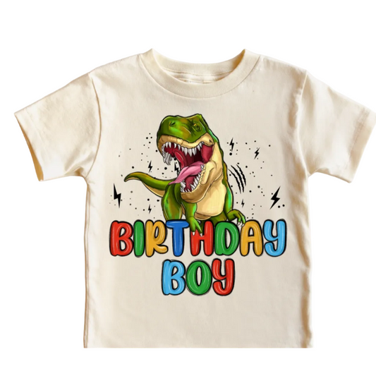cream  t-shirt with a dinosaur graphic and 'Birthday Boy' text on a white background