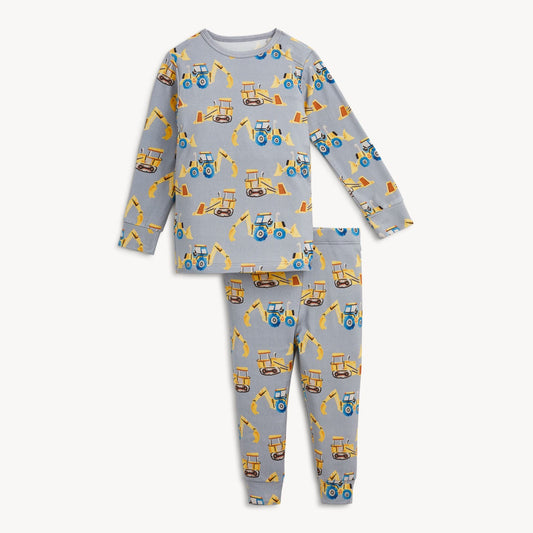 A two-piece children's pajama set featuring a light gray long-sleeve top and matching pants, both printed with a repeating pattern of yellow construction vehicles like tractors and excavators.