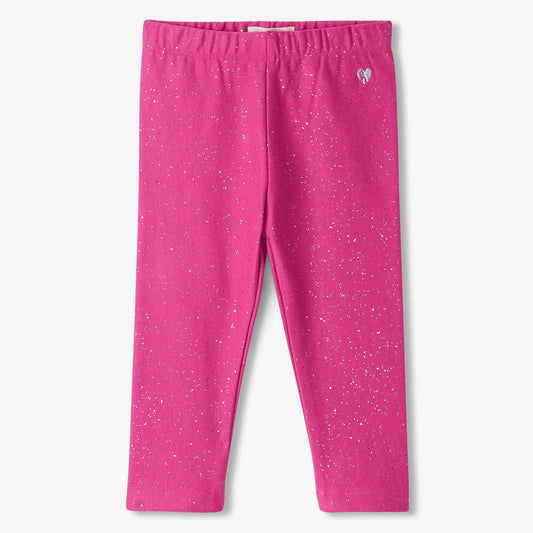 A pair of vibrant pink leggings with a speckled pattern, featuring a small heart logo at the elastic waistband.