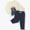 Children's outfit with a cream sweater featuring a bear design and navy pants on a white background