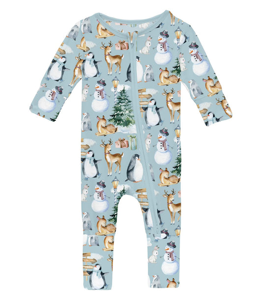 A blue baby romper with a winter woodland pattern, featuring animals such as deer and squirrels, and a Christmas tree, with a zipper at the front.