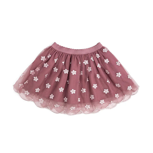 A dusty rose pink tulle tutu skirt decorated with small white embroidered flowers, shown flat against a solid white background.