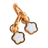 Gold charm with white opal clover-shaped pendants on a pink background