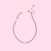 Beaded necklace with colorful beads on a pink background