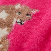Close-up of a bright pink fuzzy fabric with a partial embroidered or printed mountain lion face in white, gold glitter, and black details.