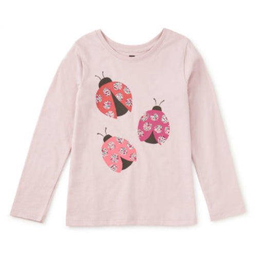 Pink long-sleeve shirt with ladybug designs on a white background