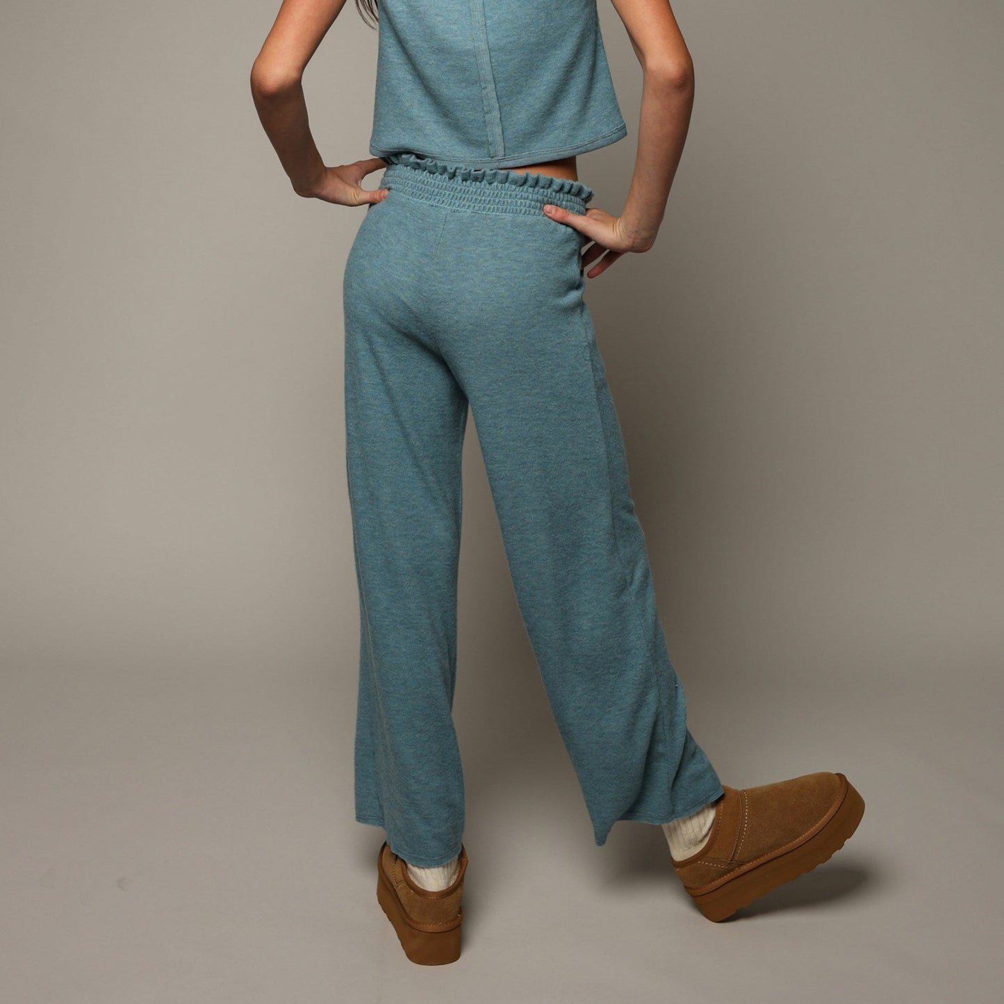 A model shown from behind wearing a matching light blue short-sleeve top and wide-leg pants set.