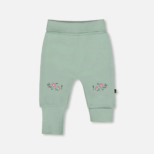 Light green baby leggings with floral embroidery on a white background