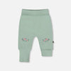 Light green baby leggings with floral embroidery on a white background