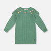 Green sweater dress with floral embroidery on a light gray background