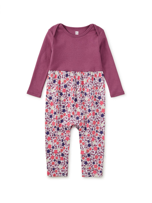 Purple top and floral pants set on a white background