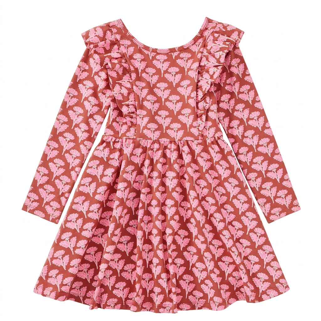 A long-sleeve children's dress with a ruffled neckline, featuring an all-over pink floral print on a terracotta brown background, laid flat against a white background.