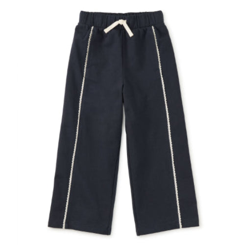 Black pants with white trim on a white background