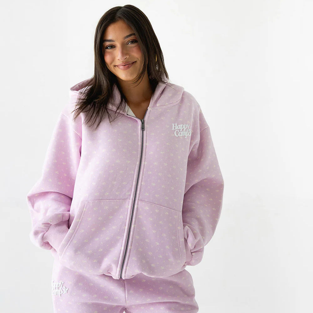 Woman wearing a pink tracksuit with a Happy Camper logo