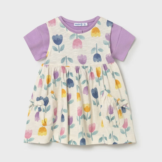 Children's dress with floral pattern and purple sleeves on a light gray background