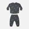 A two-piece children's pajama set in dark gray with a white crescent moon and star pattern, consisting of a long-sleeve top and matching pants, laid flat on a white background.