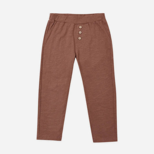 A pair of toddler's slim-fit pants in a warm rust brown color, featuring an elastic waistband and three decorative buttons down the front, displayed on a clean white background.